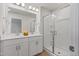 Bright bathroom boasts double sinks, white cabinets, and a glass enclosed standing shower at 907 Field Ivy Dr, Fuquay Varina, NC 27526