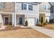 Charming gray two-story townhome with a one-car garage and a welcoming blue front door with seasonal wreath at 907 Field Ivy Dr, Fuquay Varina, NC 27526