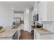 Bright kitchen showcases white cabinetry, stainless steel appliances, granite countertops, and hardwood flooring at 907 Field Ivy Dr, Fuquay Varina, NC 27526