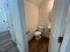 Well-lit half bathroom featuring modern fixtures, including a sleek round mirror and hardwood flooring at 97 Willow Cameron Way, Angier, NC 27501