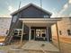 A home's exterior under construction features gray siding, white trim, and a covered porch with wooden support beams at 97 Willow Cameron Way, Angier, NC 27501