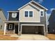 Two-story home with a mix of board and batten and lap siding, a stone base and an attached two-car garage at 97 Willow Cameron Way, Angier, NC 27501