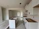 Spacious kitchen area with white cabinets and view into another room; new construction at 97 Willow Cameron Way, Angier, NC 27501