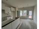 Partially installed white cabinets and a view of the backyard from the kitchen window at 97 Willow Cameron Way, Angier, NC 27501