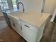 Close-up of a kitchen island featuring a white farmhouse sink and light countertops at 97 Willow Cameron Way, Angier, NC 27501