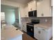 Well-lit kitchen with stainless steel appliances, white cabinetry, and island with sink at 97 Willow Cameron Way, Angier, NC 27501