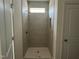 Modern tiled shower with a window and a built-in shelf, offering both style and functionality at 97 Willow Cameron Way, Angier, NC 27501