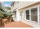 Inviting back deck featuring a wooden railing, beige siding, and a glass door that welcomes natural light into the home at 1040 Sheetbend Ln, Raleigh, NC 27606