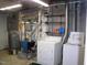 Unfinished basement laundry area featuring a washer, dryer, and storage shelving at 105 Lake Rd, Henderson, NC 27537