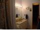 Bathroom with an open vanity, mirror, decor, lighting, and patterned shower curtain at 105 Lake Rd, Henderson, NC 27537