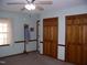 Bedroom showcasing a ceiling fan, window with curtains, and double door closets at 105 Lake Rd, Henderson, NC 27537