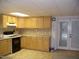 Kitchen with maple cabinets, beige countertops, white appliances, and a tiled floor at 105 Lake Rd, Henderson, NC 27537