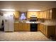 Kitchen featuring maple cabinets, a black range, white fridge, and a neutral tiled floor at 105 Lake Rd, Henderson, NC 27537