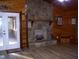 Cozy living room featuring a stone fireplace and wood-paneled walls and new flooring at 105 Lake Rd, Henderson, NC 27537