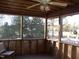 Inviting screened porch with wood framework and ceiling fan, perfect for enjoying the outdoors at 105 Lake Rd, Henderson, NC 27537
