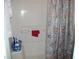 Bathroom shower with neutral-patterned curtain, and a built in shelf and soap holder at 105 Lake Rd, Henderson, NC 27537