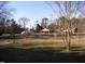 View of the large front yard with scattered trees and open green space at 105 Lake Rd, Henderson, NC 27537