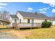 Exterior view featuring a single-story home, a wooden porch, and a convenient carport at 1231 Carolina St, Graham, NC 27253