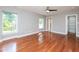 Spacious bedroom with gleaming hardwood floors, ceiling fan, and natural light from two windows at 1305 Glen Eden Dr, Raleigh, NC 27612