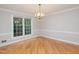 Classic dining room with polished hardwood floors, a vintage chandelier, and a large window bringing nature views in at 1305 Glen Eden Dr, Raleigh, NC 27612