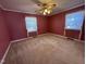 Bedroom with red walls, neutral carpet, and two well-lit windows at 1926 W Front St, Burlington, NC 27215