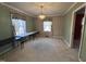 Light-filled dining room with neutral carpet, classic wallpaper, and traditional chandelier at 1926 W Front St, Burlington, NC 27215