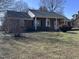 A well-maintained home with brick facade and a cozy front porch, set on a spacious lawn at 1926 W Front St, Burlington, NC 27215