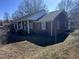 View of the right side of the brick house, displaying its architecture and landscaping on a sunny day at 1926 W Front St, Burlington, NC 27215