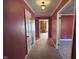 Hallway with carpet, pink walls, and access to other rooms, including one with built-in bookshelves at 1926 W Front St, Burlington, NC 27215