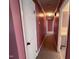 Hallway featuring mauve walls, neutral carpet and three doors at 1926 W Front St, Burlington, NC 27215