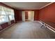 Cozy living room featuring red walls, neutral carpet, and open access to another room at 1926 W Front St, Burlington, NC 27215