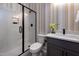 Modern bathroom features a glass shower with matte black fixtures and a gray vanity at 1964 Old Byre Way, Apex, NC 27502
