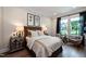 Bedroom boasts a neutral palette, a queen-size bed, two chairs, and a bright window for ample natural light at 1964 Old Byre Way, Apex, NC 27502