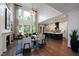 Open concept living room flowing into kitchen featuring a fireplace, hardwood floors, and large windows at 1964 Old Byre Way, Apex, NC 27502