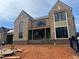 New construction home featuring wood shingle siding and black window frames against a partly cloudy sky at 214 Reynolds Rd, Raleigh, NC 27609