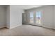 Bedroom with neutral carpet, features a double door to a porch and offers views of the surrounding community at 272 White Oak Garden Way # 209, Garner, NC 27529