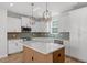 Modern kitchen featuring stainless appliances, stylish lighting, and a large island, seamlessly flowing into the living area at 272 White Oak Garden Way # 209, Garner, NC 27529