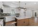 Well-lit kitchen featuring modern stainless appliances, white cabinets, and eye-catching pendant lighting and a large island at 272 White Oak Garden Way # 209, Garner, NC 27529