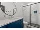 Modern bathroom features a floating vanity, round mirror, and a glass-enclosed shower at 299 Seaforth Landing Dr, Pittsboro, NC 27312