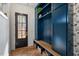 Charming entryway featuring a custom blue storage unit with bench and decorative wallpaper at 299 Seaforth Landing Dr, Pittsboro, NC 27312