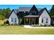 Beautiful two-tone home featuring contrasting white and black accents, stylish front porch, and manicured lawn at 299 Seaforth Landing Dr, Pittsboro, NC 27312