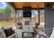 Cozy outdoor patio with a stone fireplace, comfortable seating, and wooded views at 299 Seaforth Landing Dr, Pittsboro, NC 27312