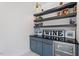 Custom wine bar features floating shelves, a mini fridge, custom cabinets, and decor at 299 Seaforth Landing Dr, Pittsboro, NC 27312