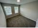Carpeted bedroom with two windows providing natural light, neutral paint, and a closet at 3024 Freewinds Way # 49, Cary, NC 27519