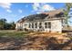 View of the home's backyard with multiple windows and a small porch with stairs at 406 Stewart Town Rd, Lillington, NC 27546