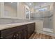 Well-lit bathroom featuring dual sinks, granite countertops, and a modern walk-in shower at 406 Stewart Town Rd, Lillington, NC 27546