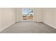 Cozy bedroom featuring neutral-toned carpet and a large window with a view of the surrounding landscape at 406 Stewart Town Rd, Lillington, NC 27546