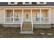 Inviting home exterior with a covered front porch, white railings, and classic design elements at 406 Stewart Town Rd, Lillington, NC 27546