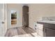 Well-lit laundry room with custom cabinets, a utility sink, and an exterior door to the backyard at 406 Stewart Town Rd, Lillington, NC 27546