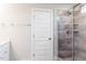 Bathroom with tiled shower featuring glass door, corner shelves and white door with towel rack at 456 Barbour Farm Ln, Four Oaks, NC 27524